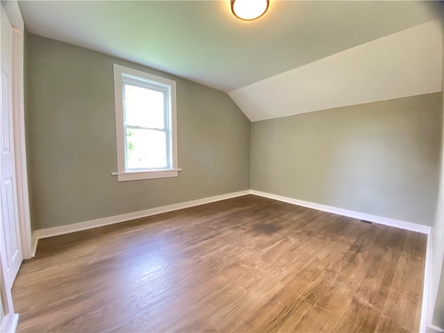 bonus room with dark hardwood / wood-style flooring and lofted ceiling