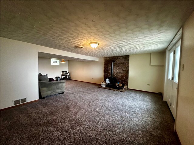 interior space with brick wall, carpet, and a wood stove