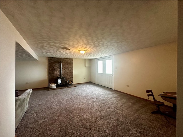 additional living space featuring carpet flooring, a textured ceiling, brick wall, and a wood stove