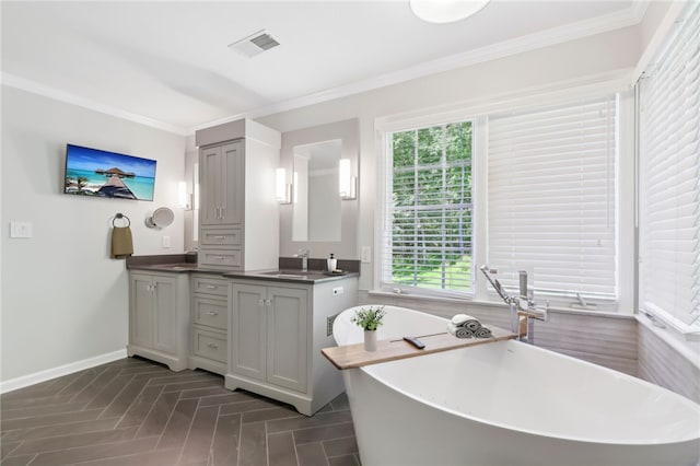 bathroom with vanity, ornamental molding, and a tub to relax in