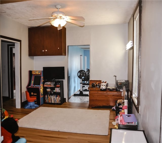 interior space with ceiling fan, dark brown cabinets, and light tile patterned floors