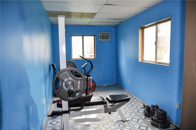 exercise area with light tile patterned floors, plenty of natural light, and a paneled ceiling