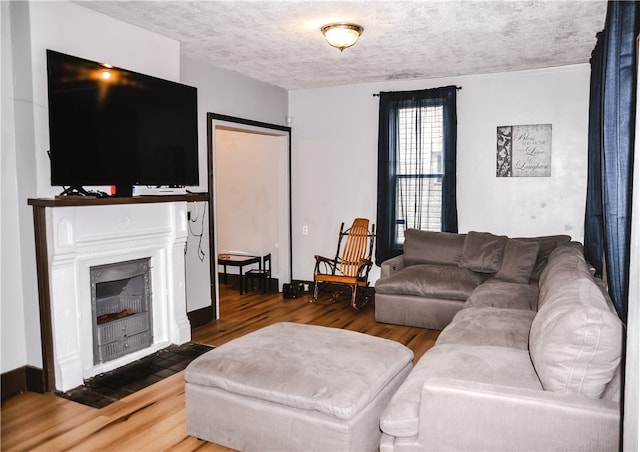 living room featuring hardwood / wood-style floors, a textured ceiling, and a fireplace