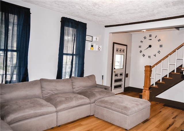 living room with plenty of natural light, a textured ceiling, and wood-type flooring