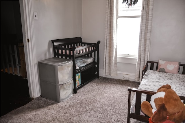 bedroom with carpet floors, multiple windows, and a crib