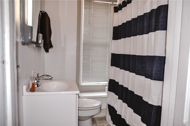 bathroom featuring tile patterned flooring, curtained shower, vanity, and toilet