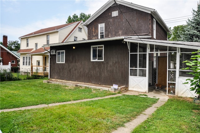 back of house with a sunroom and a yard