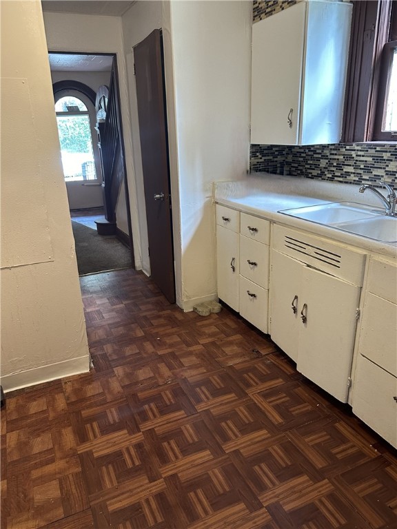 bathroom with vanity, backsplash, and parquet flooring