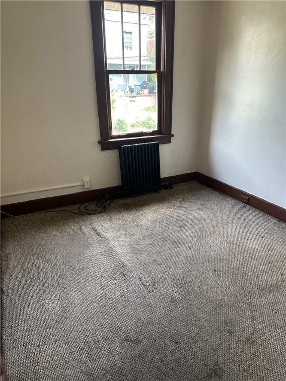 empty room featuring carpet flooring and radiator