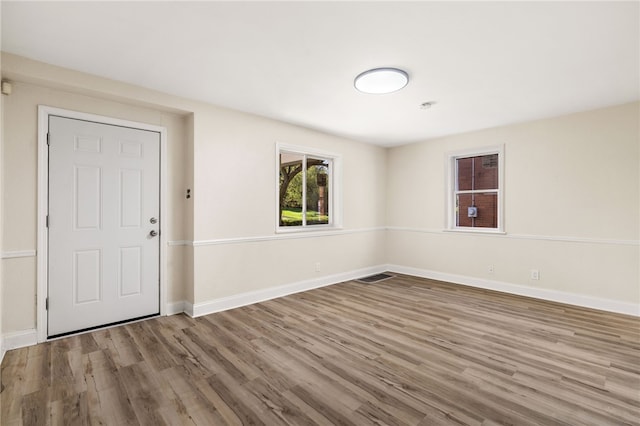 unfurnished room with visible vents, baseboards, and wood finished floors