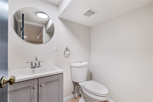 bathroom with visible vents, toilet, vanity, and baseboards