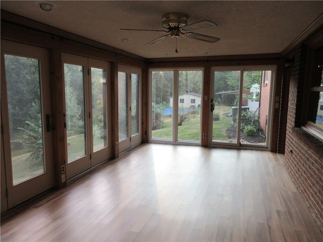 unfurnished sunroom featuring ceiling fan