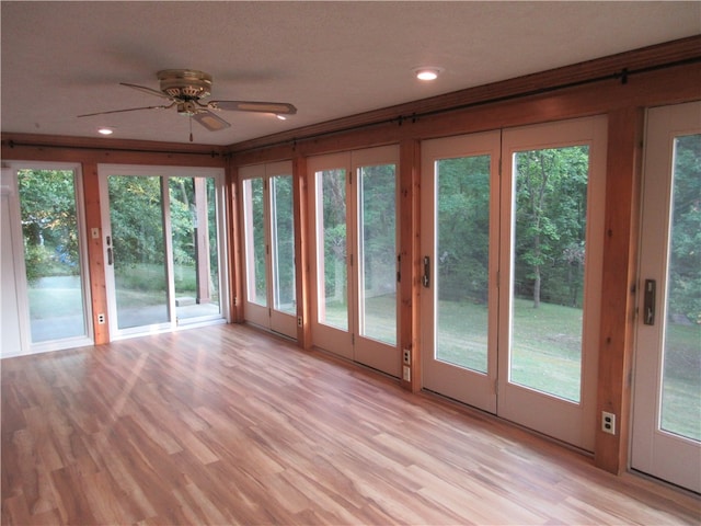 unfurnished sunroom with plenty of natural light and ceiling fan