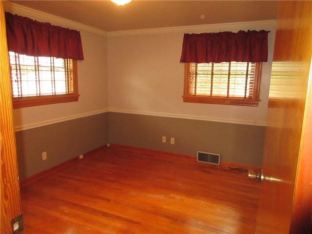 unfurnished room featuring a wealth of natural light, hardwood / wood-style flooring, and crown molding