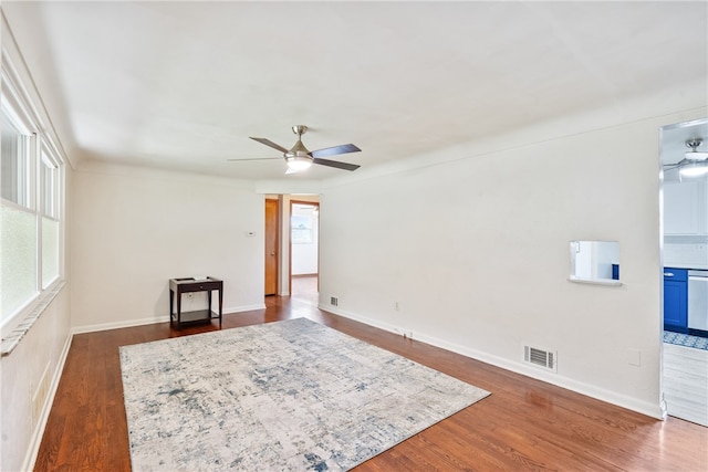 sitting room with ceiling fan and dark wood-type flooring