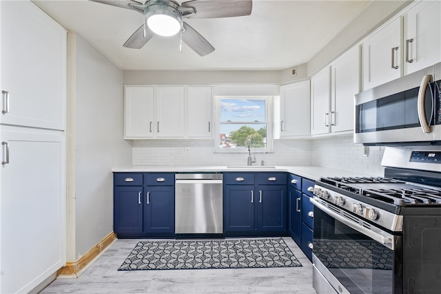 kitchen with backsplash, stainless steel appliances, blue cabinetry, and light wood-type flooring