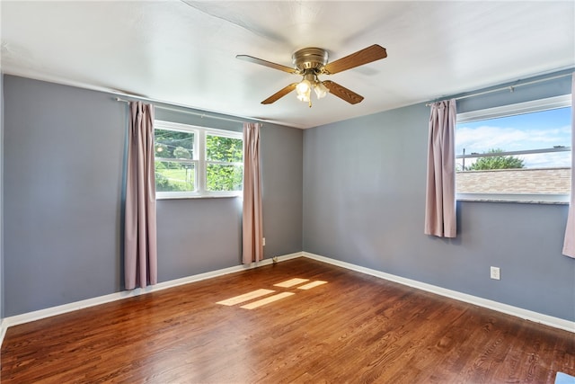 spare room with dark hardwood / wood-style flooring and ceiling fan