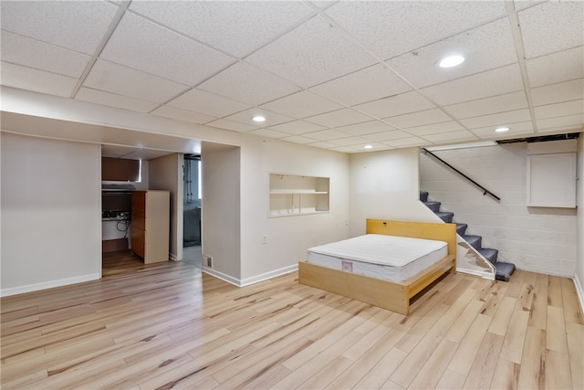 bedroom with light hardwood / wood-style floors and a drop ceiling