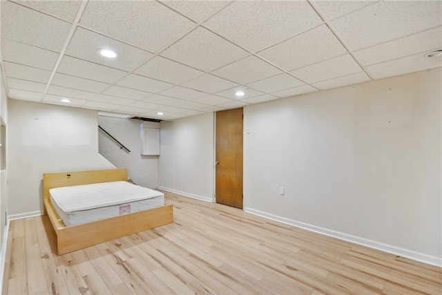 unfurnished bedroom with light hardwood / wood-style floors and a paneled ceiling