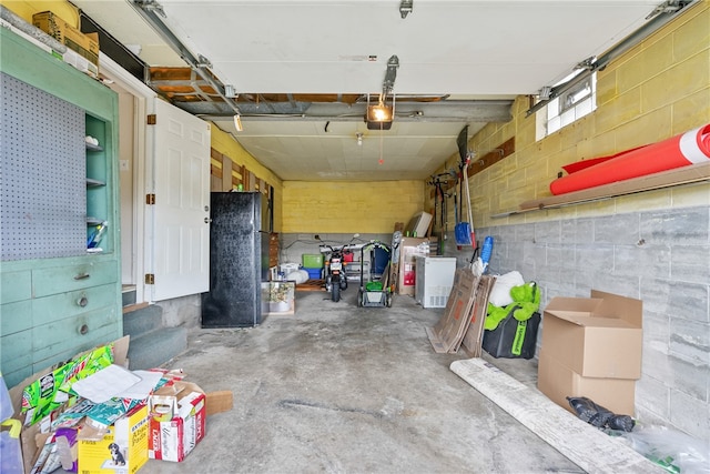 garage with black fridge and a garage door opener