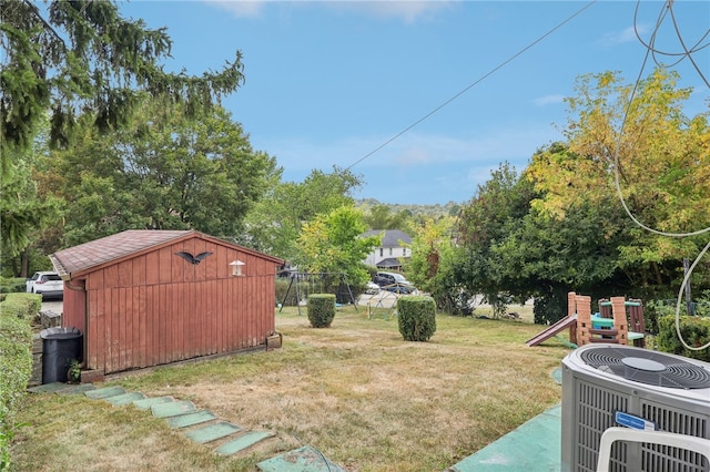 view of yard featuring central air condition unit, a playground, and a shed