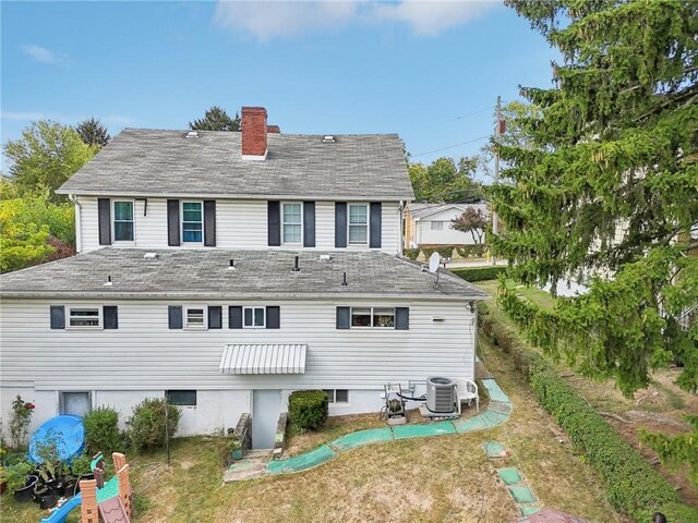 rear view of property with a lawn and central AC