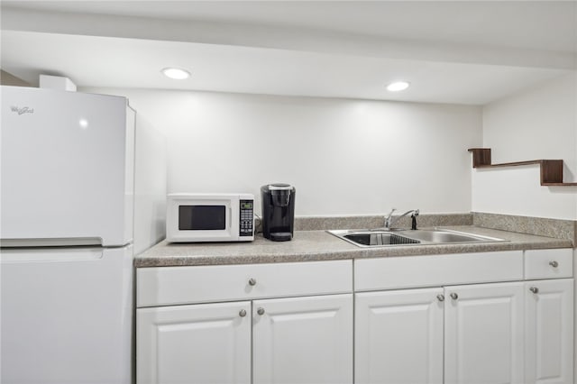 kitchen with sink, white appliances, and white cabinets