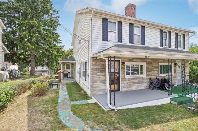 rear view of house featuring a lawn