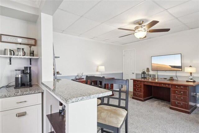 kitchen with white cabinetry, a drop ceiling, kitchen peninsula, ceiling fan, and light carpet