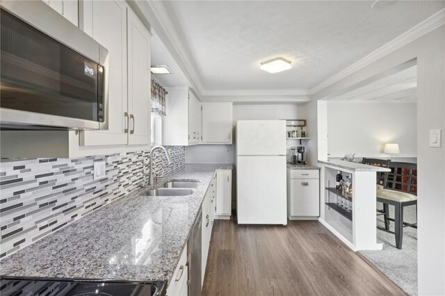 kitchen with light stone counters, stainless steel appliances, dark wood-type flooring, and white cabinets