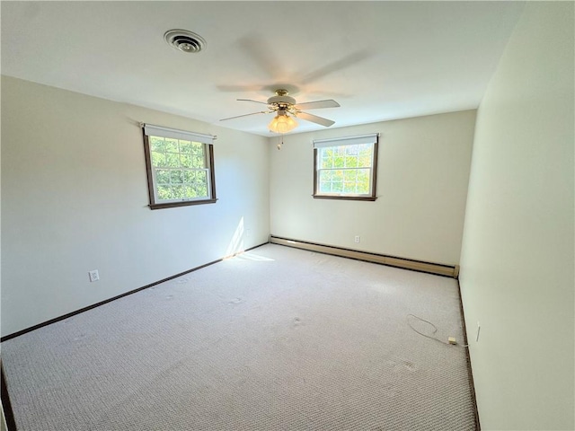 carpeted empty room featuring a healthy amount of sunlight, ceiling fan, and a baseboard radiator