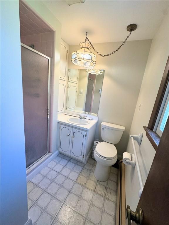 bathroom featuring vanity, an enclosed shower, and toilet