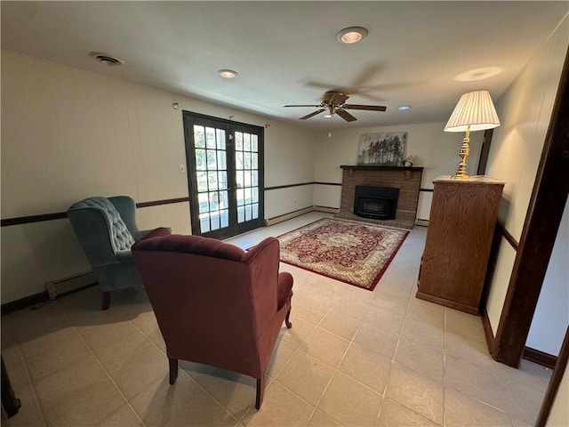 living room featuring french doors, a brick fireplace, ceiling fan, a baseboard radiator, and light tile patterned flooring