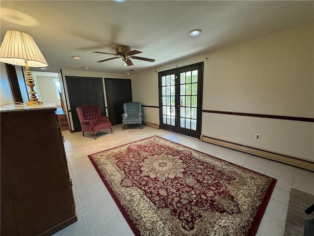 sitting room featuring french doors, light tile patterned floors, baseboard heating, and ceiling fan