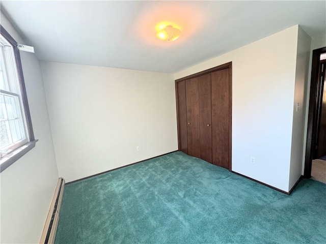 unfurnished bedroom with a closet, light colored carpet, and a baseboard heating unit