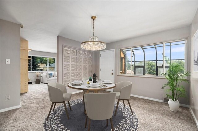 dining space featuring a notable chandelier and carpet floors