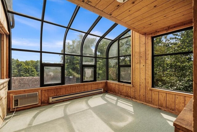 unfurnished sunroom featuring baseboard heating, a wall unit AC, and lofted ceiling