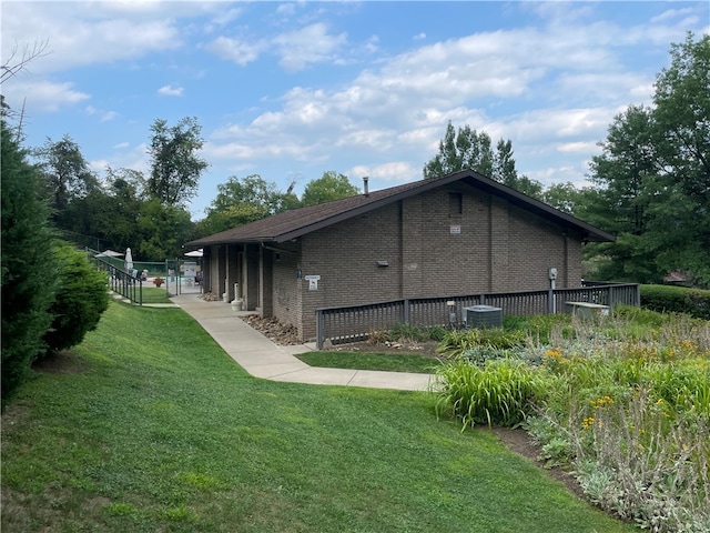 view of home's exterior featuring cooling unit and a yard