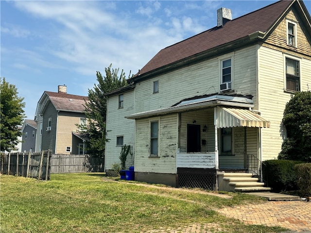 rear view of house featuring a lawn