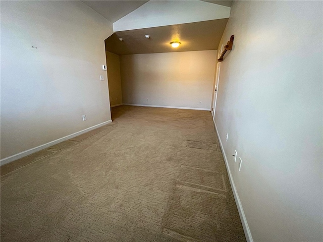 unfurnished room featuring light carpet and vaulted ceiling