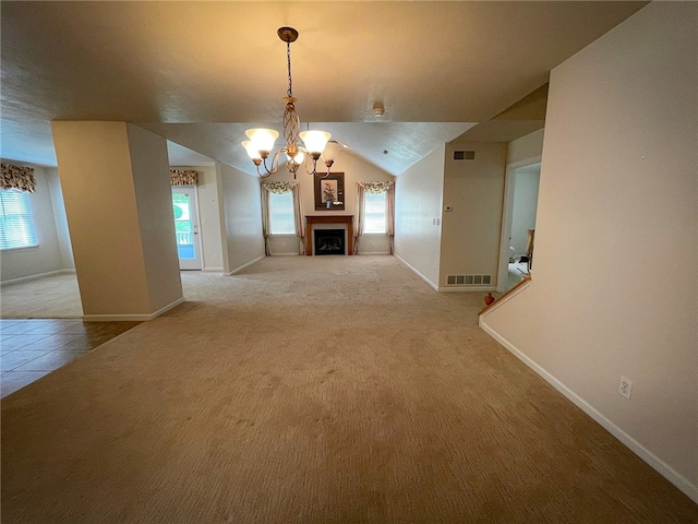 unfurnished dining area with lofted ceiling, a healthy amount of sunlight, a chandelier, and light colored carpet