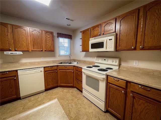 kitchen featuring white appliances, sink, and light tile patterned flooring