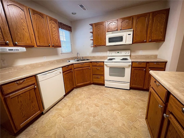 kitchen featuring white appliances, light tile patterned floors, and sink