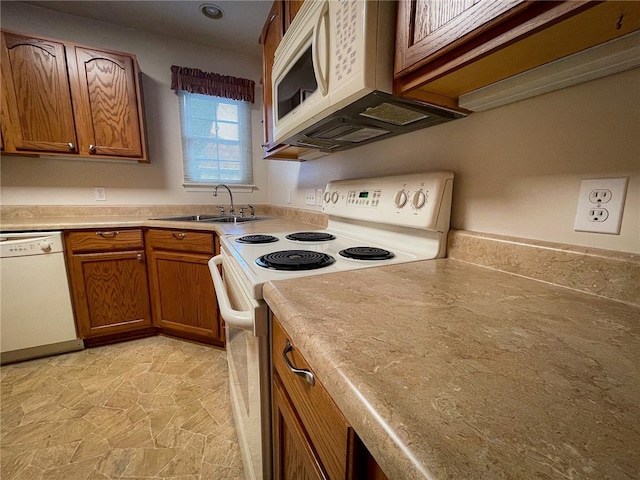 kitchen with light tile patterned floors, white appliances, and sink