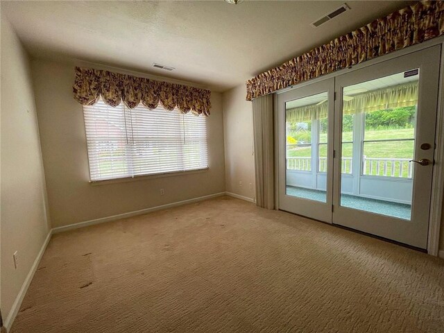 carpeted empty room featuring french doors