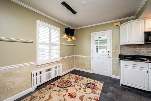 kitchen featuring crown molding, hanging light fixtures, white cabinetry, and radiator heating unit