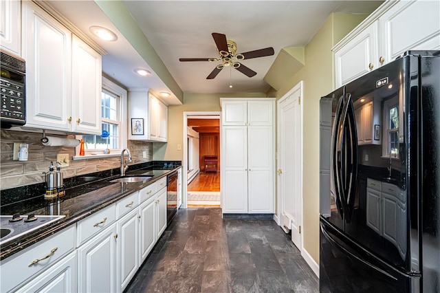 kitchen featuring tasteful backsplash, sink, white cabinetry, black appliances, and ceiling fan