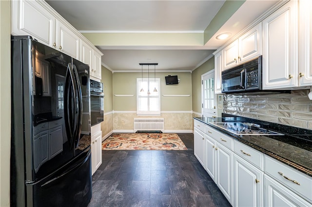 kitchen with black appliances, white cabinets, radiator heating unit, and decorative light fixtures