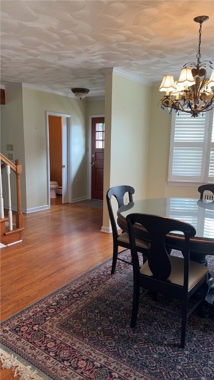 dining room with an inviting chandelier, hardwood / wood-style floors, and a textured ceiling