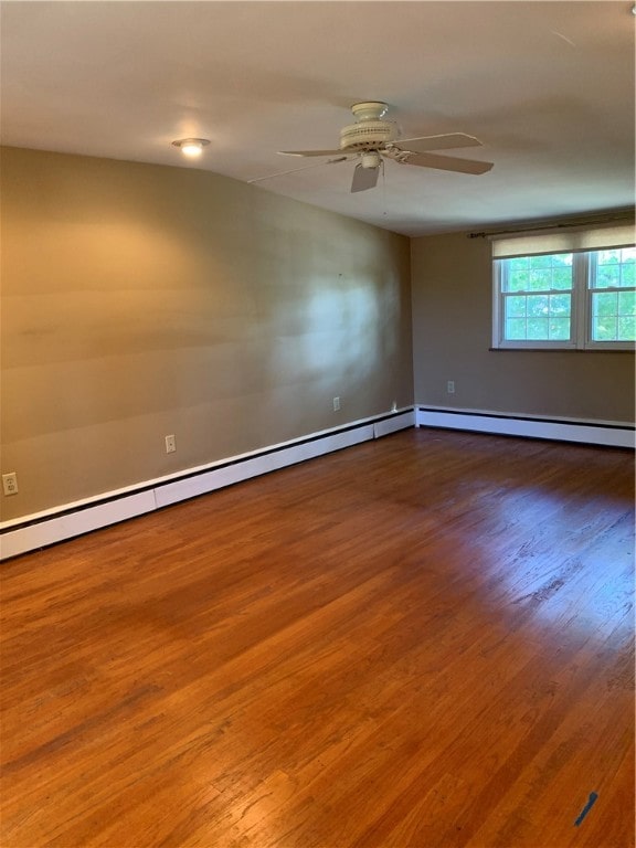 empty room with ceiling fan, baseboard heating, and hardwood / wood-style floors